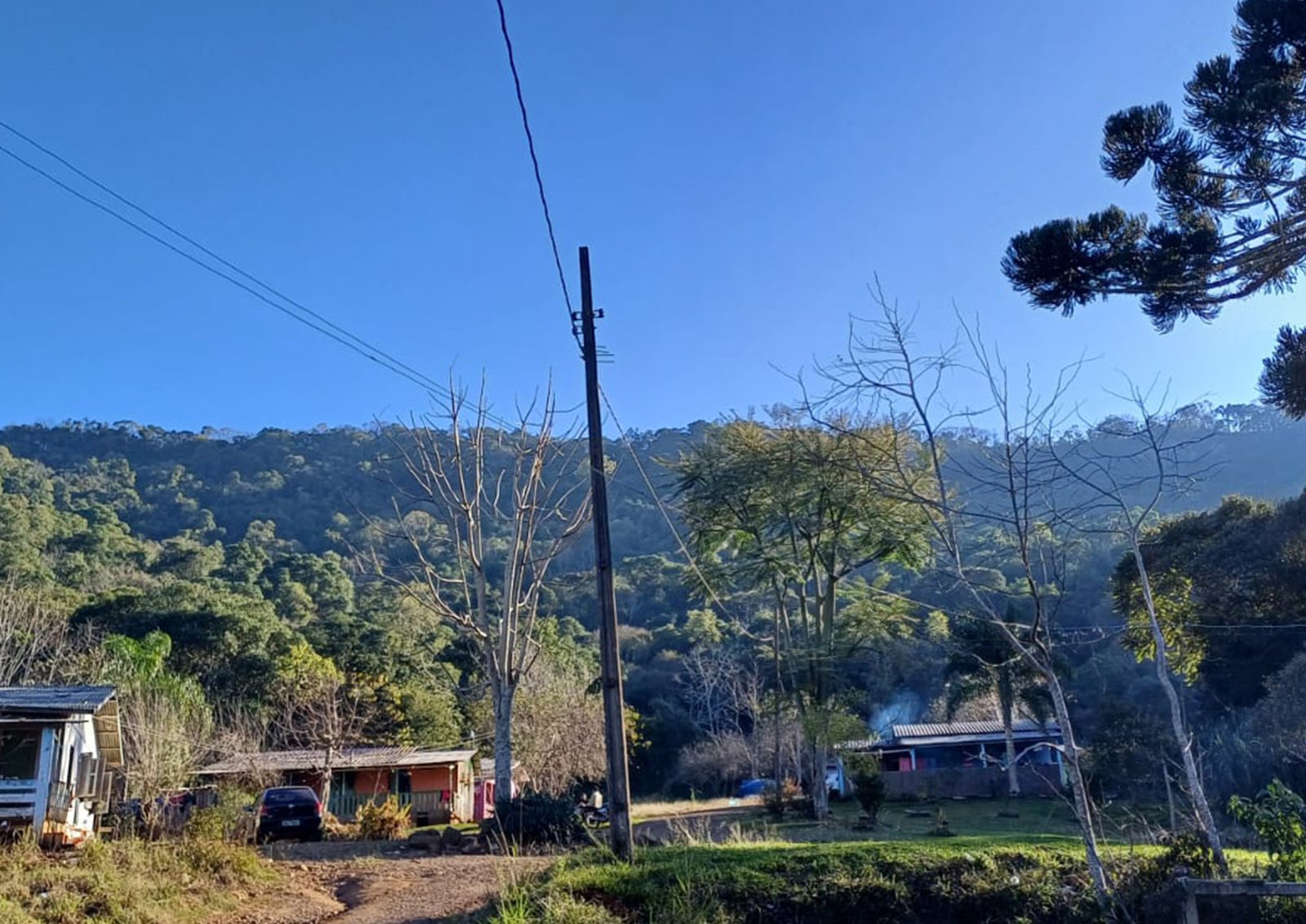 Área comunitária na Terra Indígena Toldo Pinhal com campo de futebol e residências ao fundo.